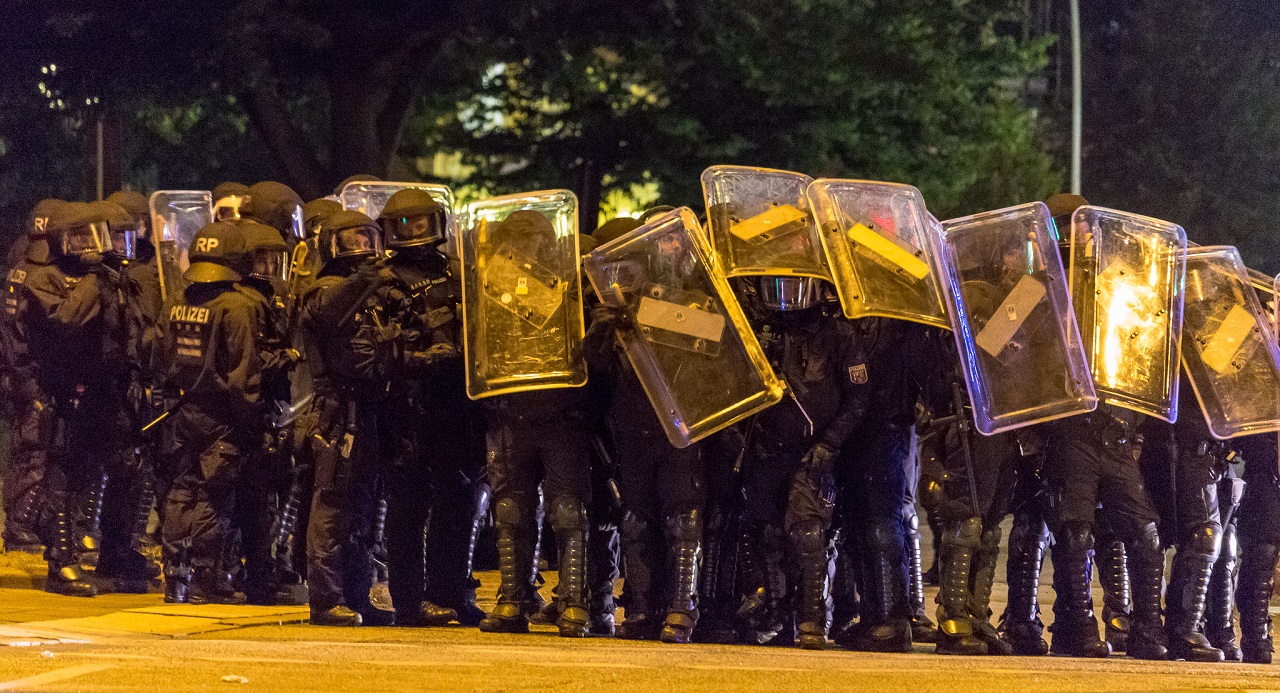 Polizeieinheit-Kampfmontur-Schlagstoecke-Polizeiterror-technische-Hochruestung-martilische-Gewandung-Polizei-Face-Shield-Kritisches-Netzwerk-Taeter-in-Uniform